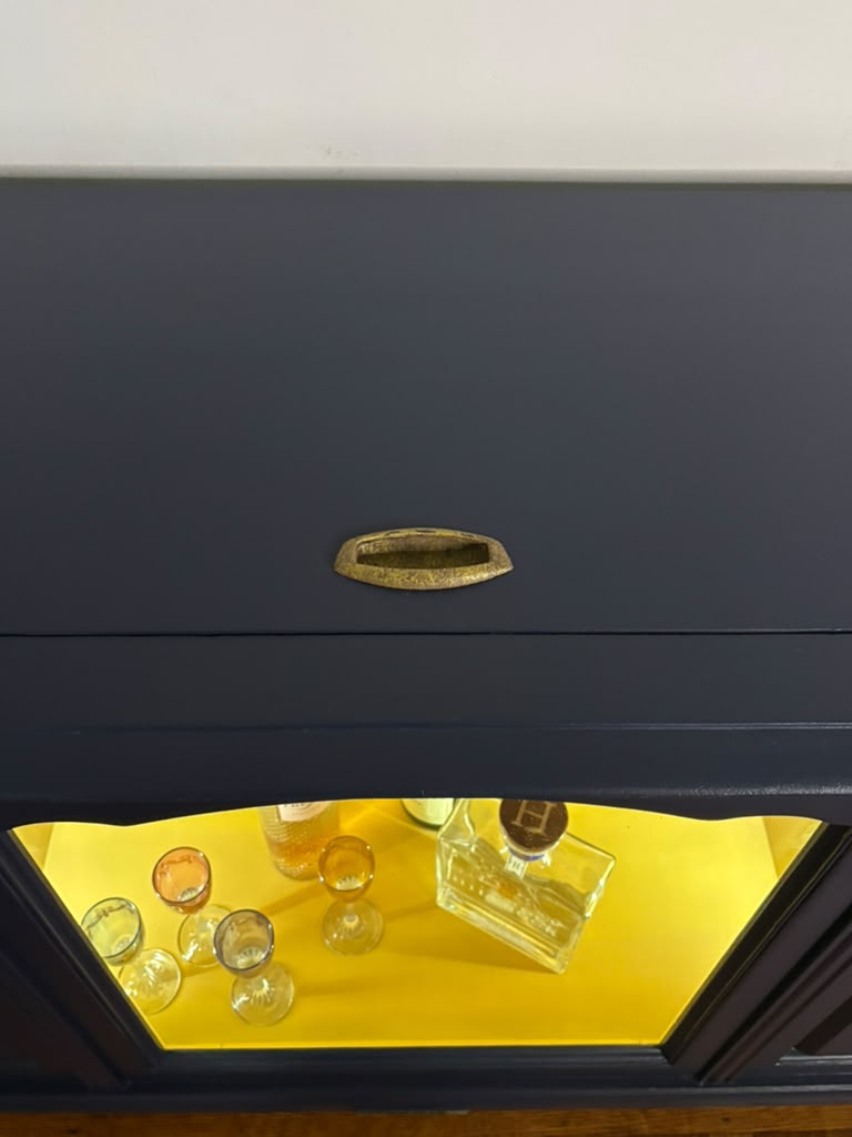 Vintage Victrola transformed into a striking liquor cabinet with Navy Blue and Carnaby Yellow finishes, glass shelves, and remote-controlled lighting
