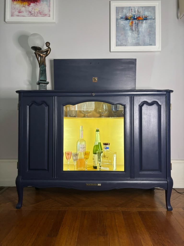 Vintage Victrola transformed into a striking liquor cabinet with Navy Blue and Carnaby Yellow finishes, glass shelves, and remote-controlled lighting