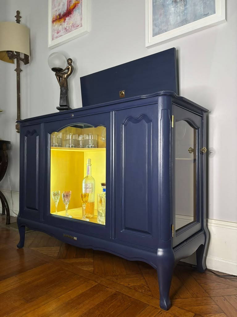 Vintage Victrola transformed into a striking liquor cabinet with Navy Blue and Carnaby Yellow finishes, glass shelves, and remote-controlled lighting