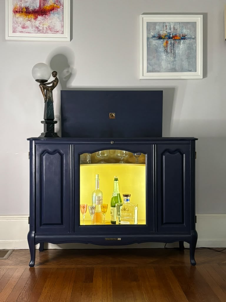 Vintage Victrola transformed into a striking liquor cabinet with Navy Blue and Carnaby Yellow finishes, glass shelves, and remote-controlled lighting