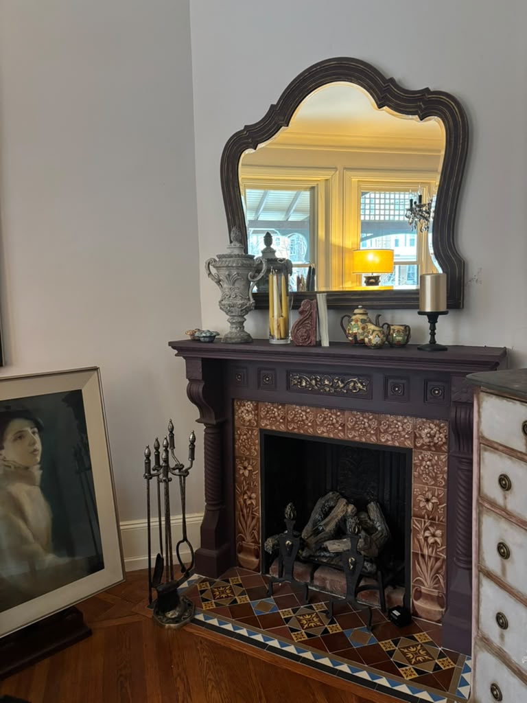 A one-of-a-kind Victorian mantel mirror featuring an original mirror, rich aubergine finish with bronze undertones, and timeless English manor elegance
