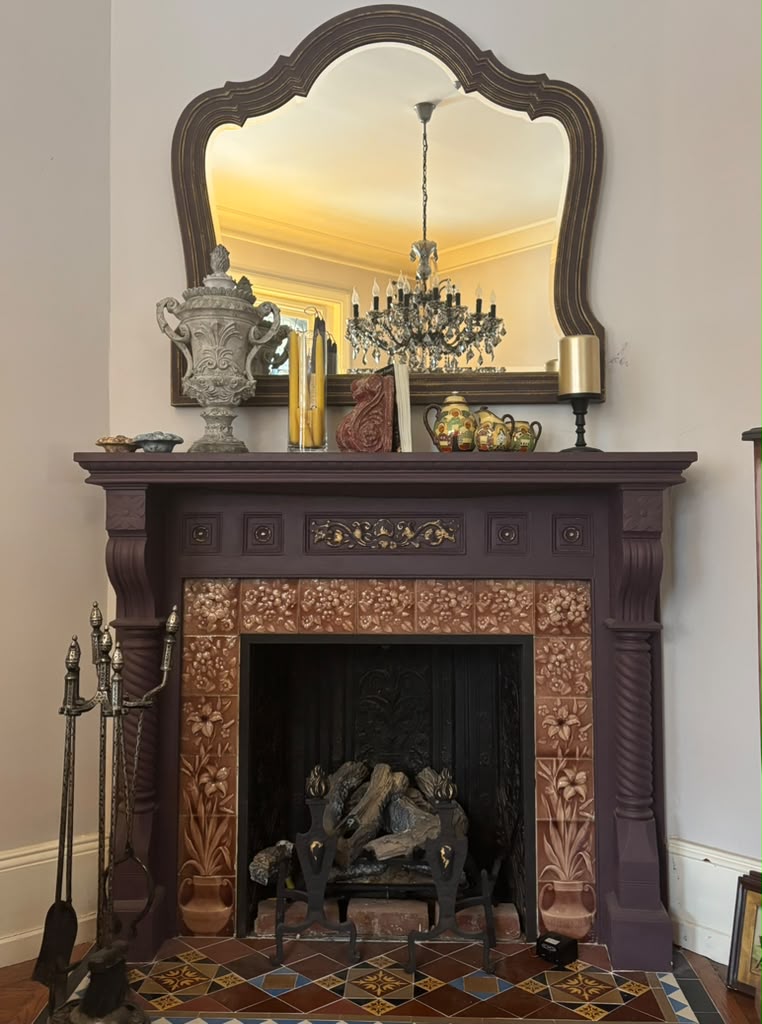 A one-of-a-kind Victorian mantel mirror featuring an original mirror, rich aubergine finish with bronze undertones, and timeless English manor elegance